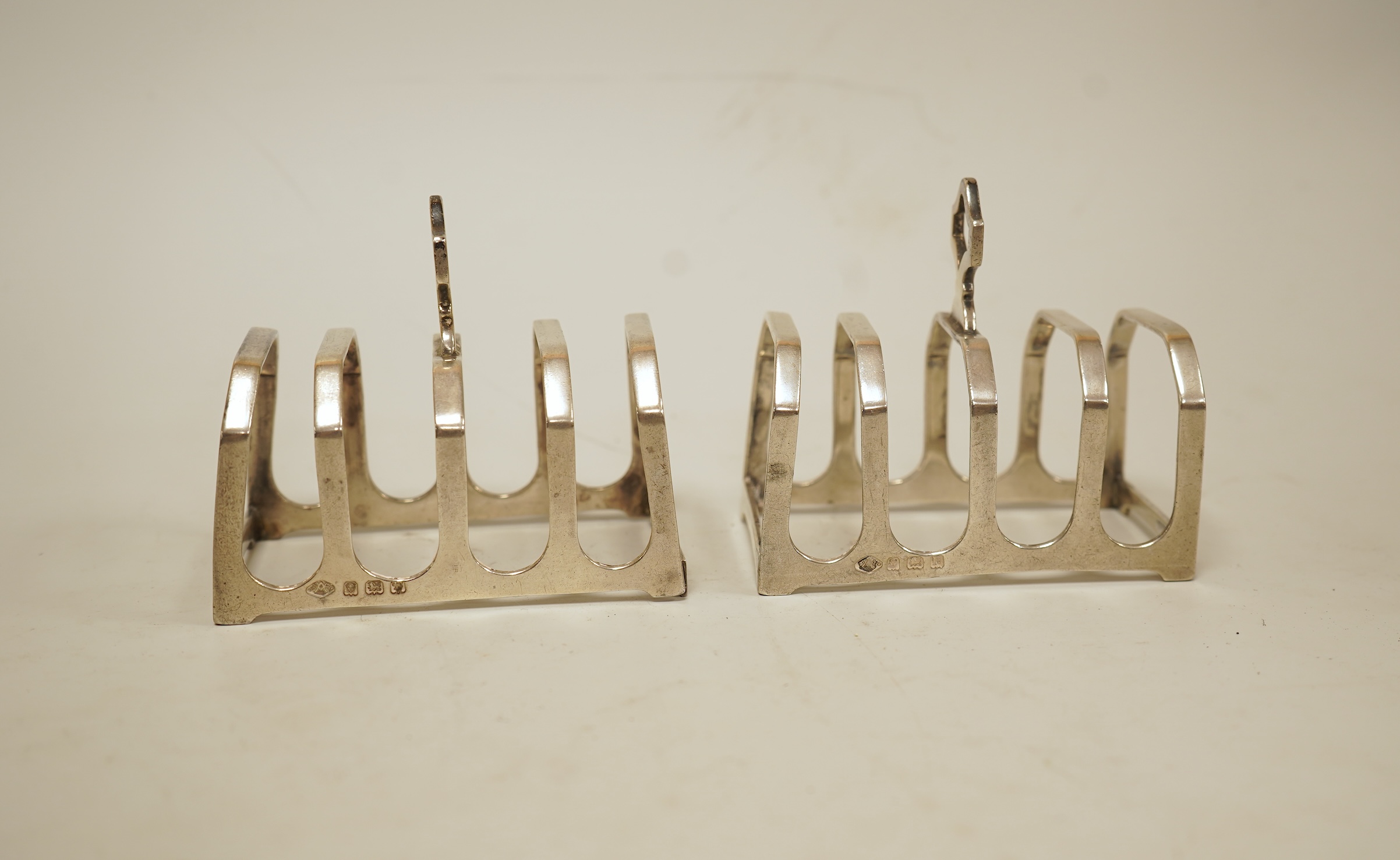 A pair of small George V silver five bar toast racks, Adie Brothers, Birmingham, 1930, length 76mm, together with six assorted silver condiments.